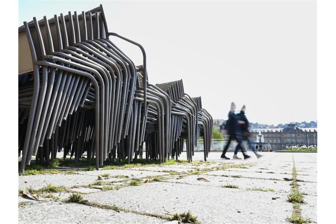 Stühle eines Straßencafes stehen gestapelt auf dem Schlossplatz. Foto: Bernd Weißbrod/dpa/Archivbild