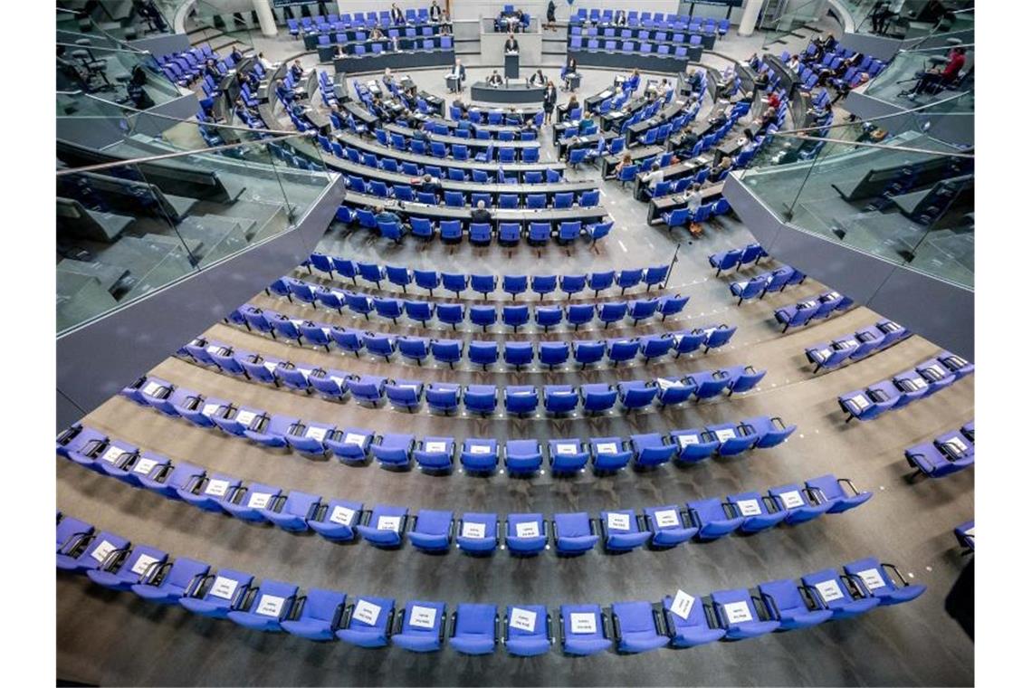 Stühle für die Abgeordneten, aufgenommen im Plenum in Deutschen Bundestag. Auf einigen der Stühle liegen Zettel mit der Aufschrift "Bitte frei lassen". Foto: Michael Kappeler/dpa