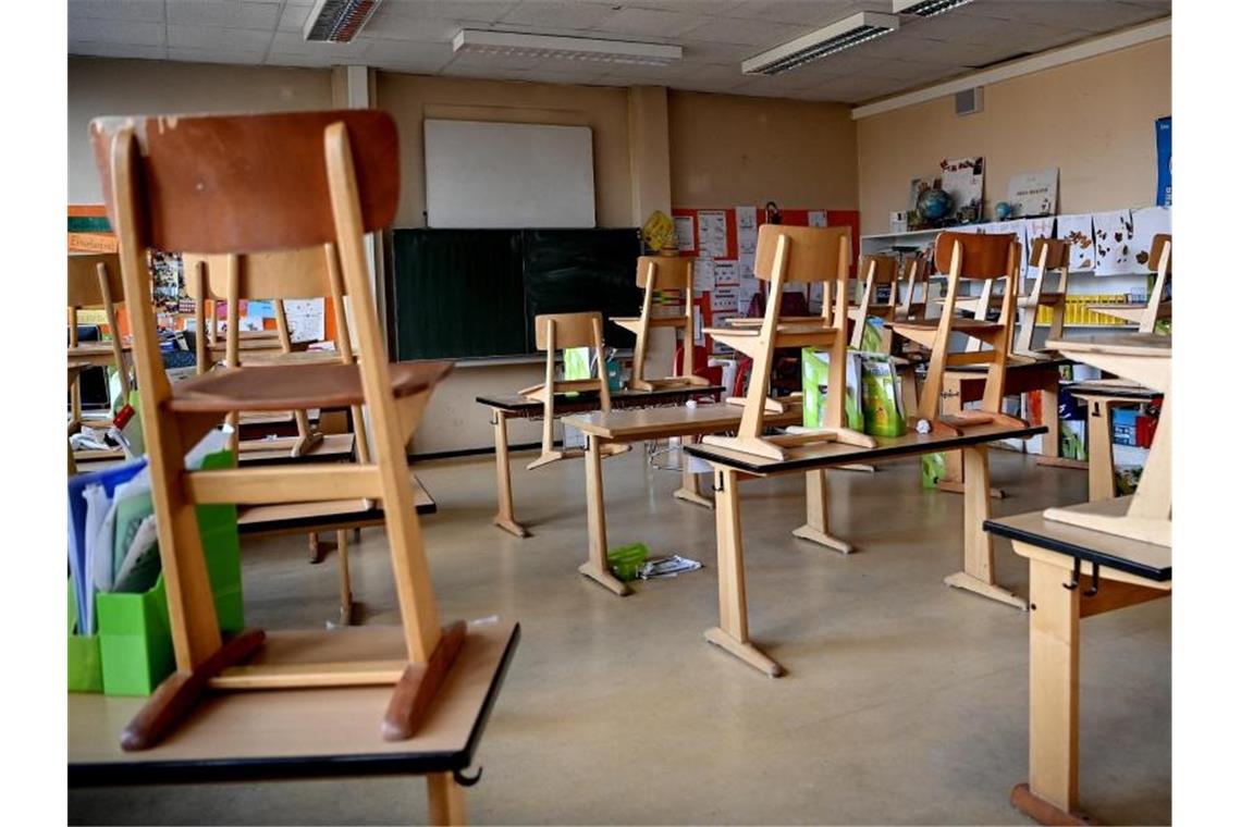 Stühle sind in einem Klassenzimmer hochgestellt. Foto: Britta Pedersen/dpa-Zentralbild/dpa