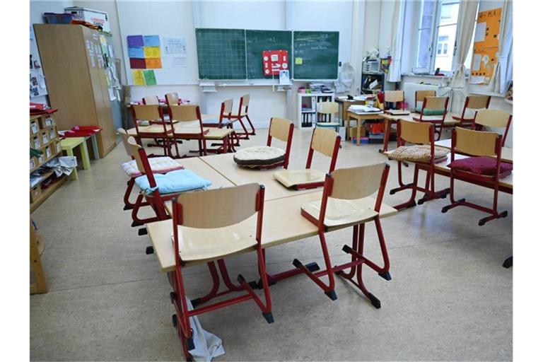 Stühle sind in einem leeren Klassenzimmer in einer Schule in Frankfrut auf den Tischen abgestellt. Foto: Arne Dedert/dpa