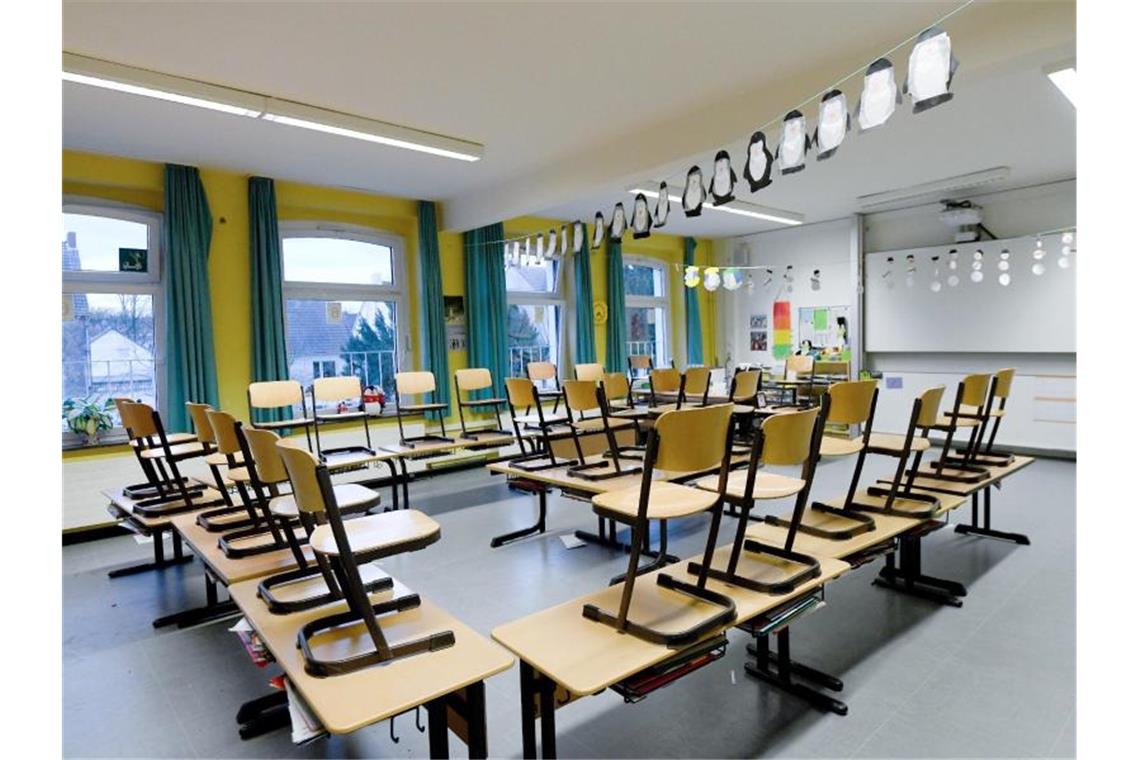 Stühle stehen in einem Klassenzimmer auf den Tischen. Foto: Caroline Seidel/dpa/Archivbild