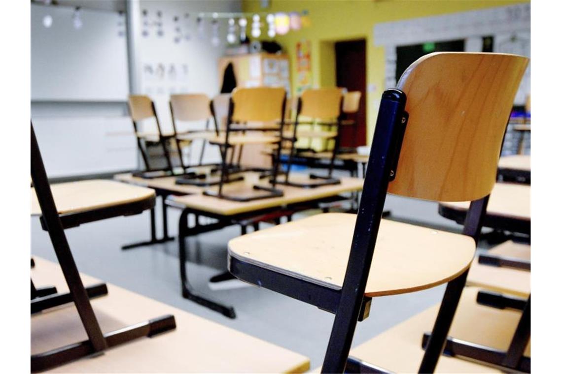 Stühle stehen in einem Klassenzimmer in einer Grundschule auf den Tischen. Foto: Caroline Seidel/dpa