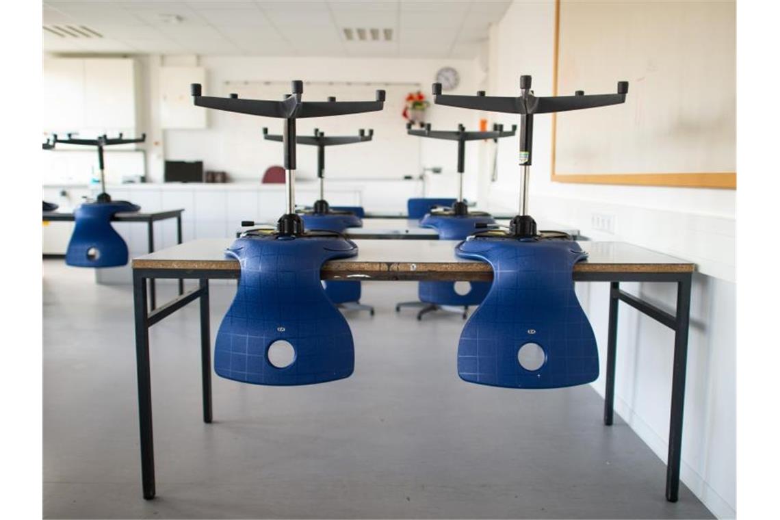 Stühle stehen in einem leeren Klassenzimmer in einem Gymnasium auf den Tischen, da der Unterricht in der Corona-Zeit ausgefallen ist. Foto: Jonas Güttler/dpa