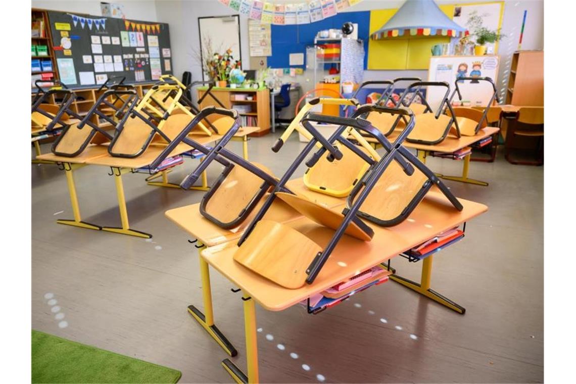 Stühle stehen in einer Grundschule in Stuttgart nach Ende der letzten Unterrichtsstunde auf den Tischen. Foto: Sebastian Gollnow/dpa