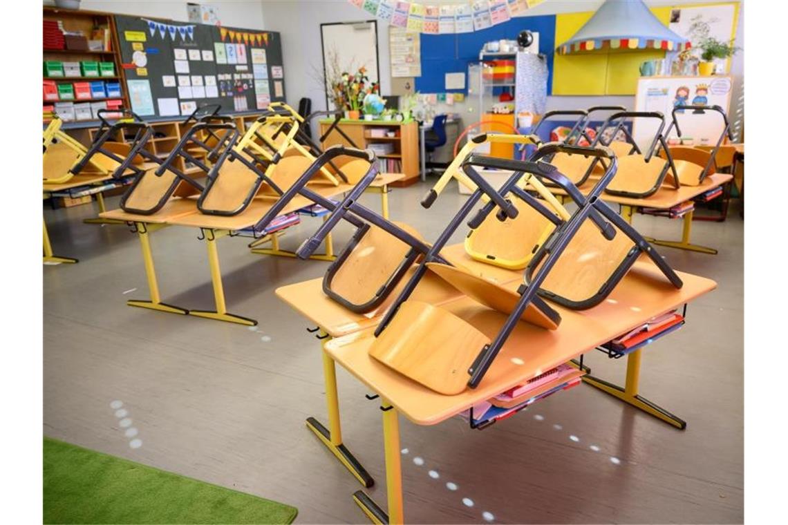 Stühle stehen in einer Grundschule nach Ende der letzten Unterrichtsstunde auf den Tischen. Foto: Sebastian Gollnow/dpa/Archivbild