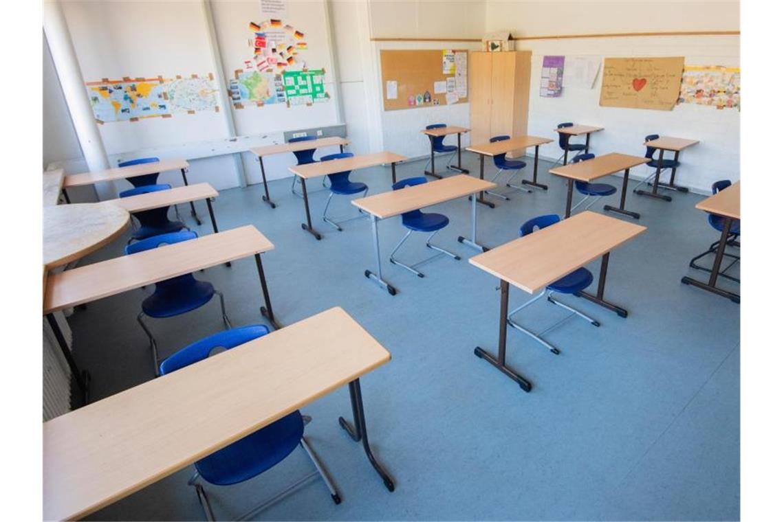 Stühle und Tische stehen im Abstand von jeweils zwei Metern in einem Klassenzimmer. Foto: Julian Stratenschulte/dpa/Symbolbild