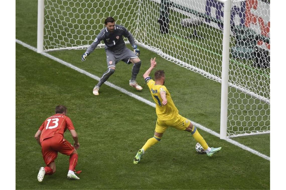 Stürmer Andrej Jarmolenko (r) erzielt das Tor zur 1:0-Führung gegen Nordmazedoniens Torwart Stole Dimitrievski (oben). Foto: Mihai Barbu/AFP Pool/AP/dpa