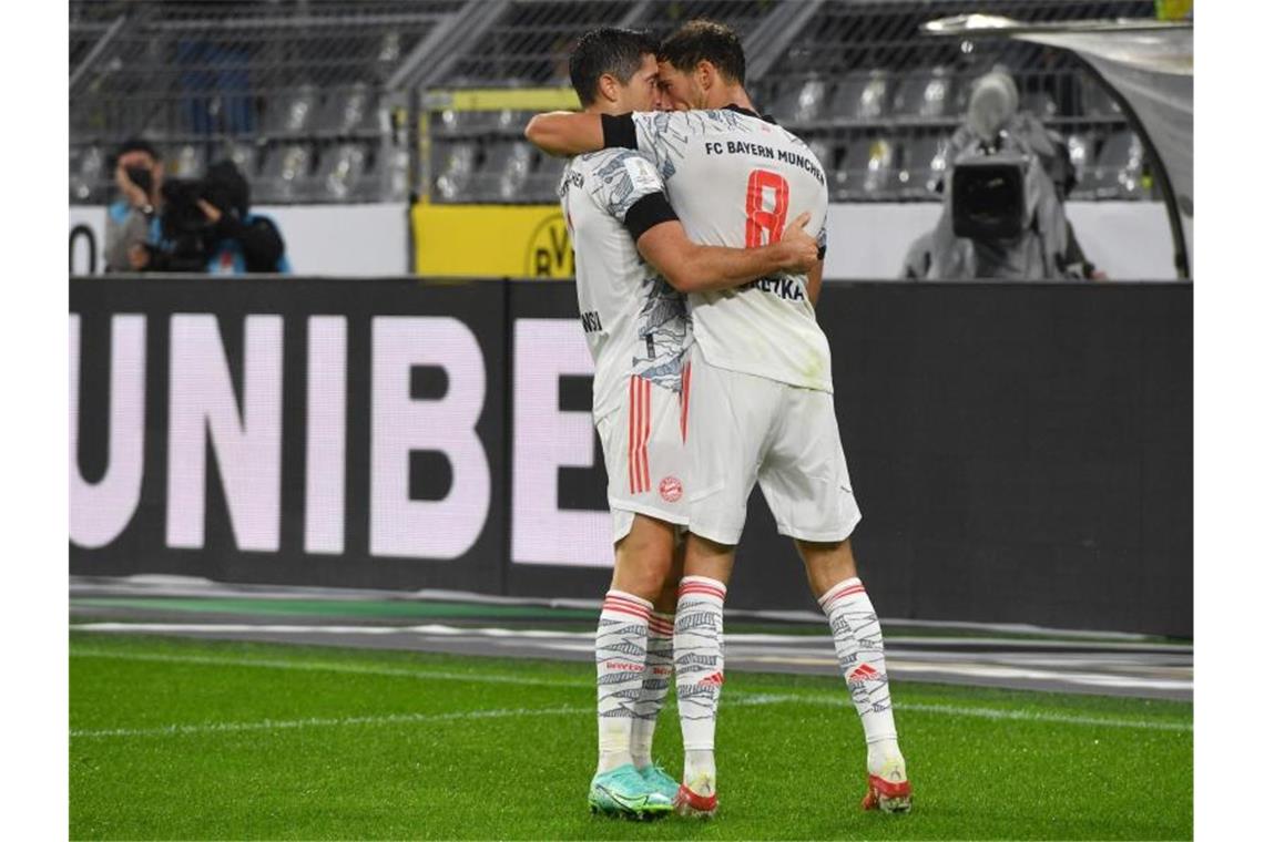 Stürmer-Star Robert Lewandowski (l) brachte den FC Bayern München mit dem wichtigen Tor zum 1:0 gegen den BVB auf die Siegerstraße. Foto: Bernd Thissen/dpa