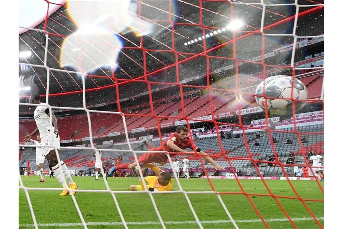 Stürmer Thomas Müller (r) erzielt das Tor zur 2:0-Führung gegen Eintracht Frankfurt. Foto: Andreas Gebert/Reuters-Pool/dpa