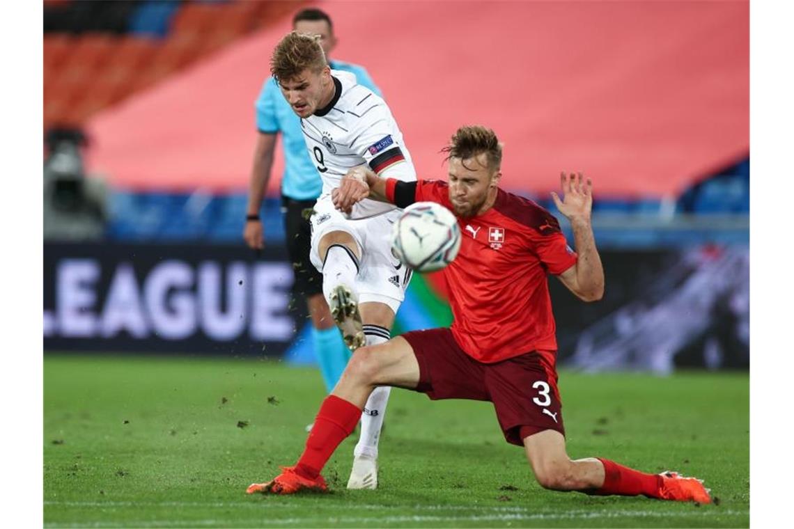 Stürmer Timo Werner (l) kommt gegen Silvan Widmer zum Torabschluss. Foto: Christian Charisius/dpa