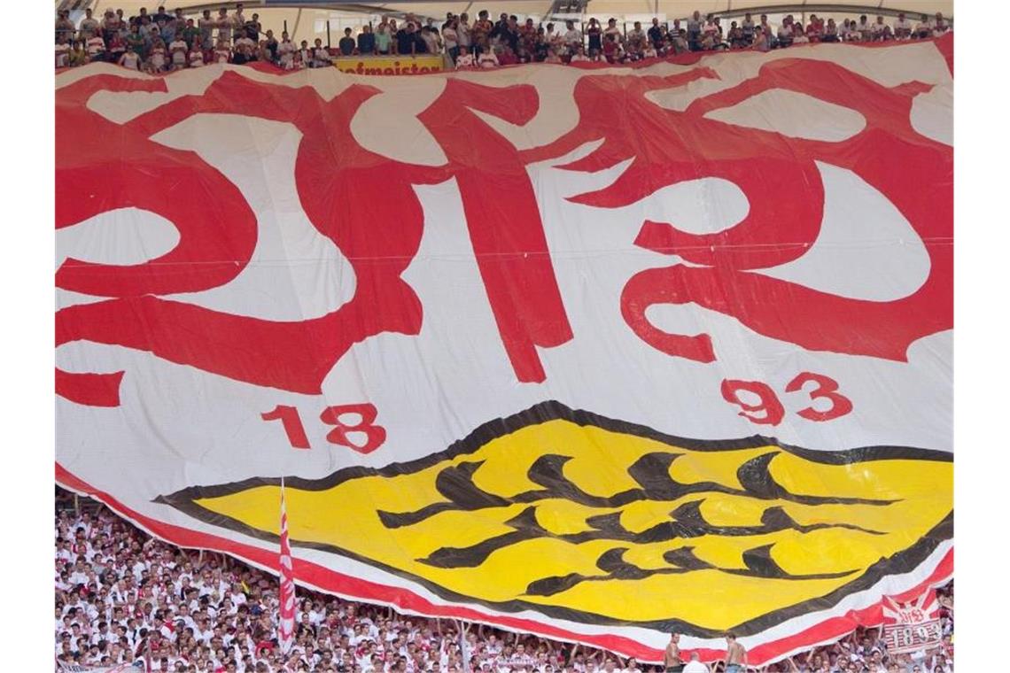 Stuttgarter Fans breiten vor dem Spiel einen Banner mit dem Logo des VfB Stuttgart aus. Foto: Sebastian Kahnert/dpa