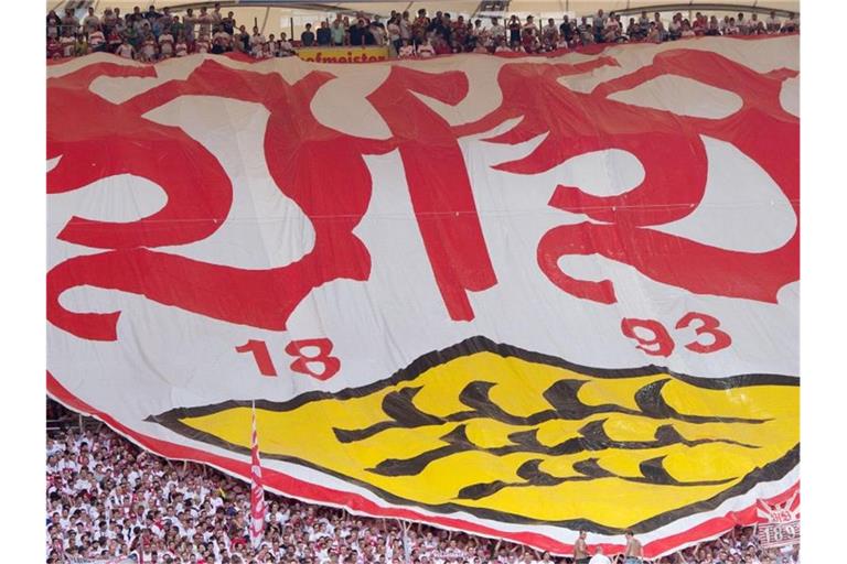 Stuttgarter Fans breiten vor dem Spiel einen Banner mit dem Logo des VfB Stuttgart aus. Foto: Sebastian Kahnert/dpa/Archivbild