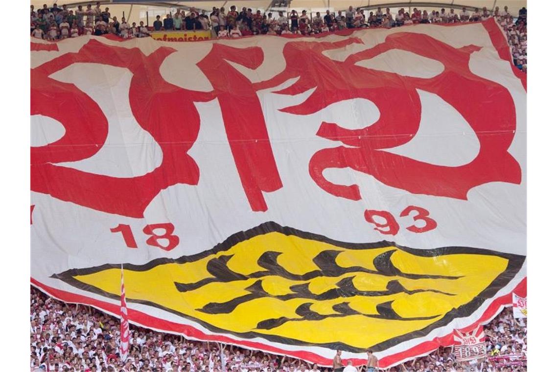 Stuttgarter Fans breiten vor einem Spiel einen Banner mit dem Logo des VfB Stuttgart aus. Foto: Sebastian Kahnert/dpa/Symbolbild