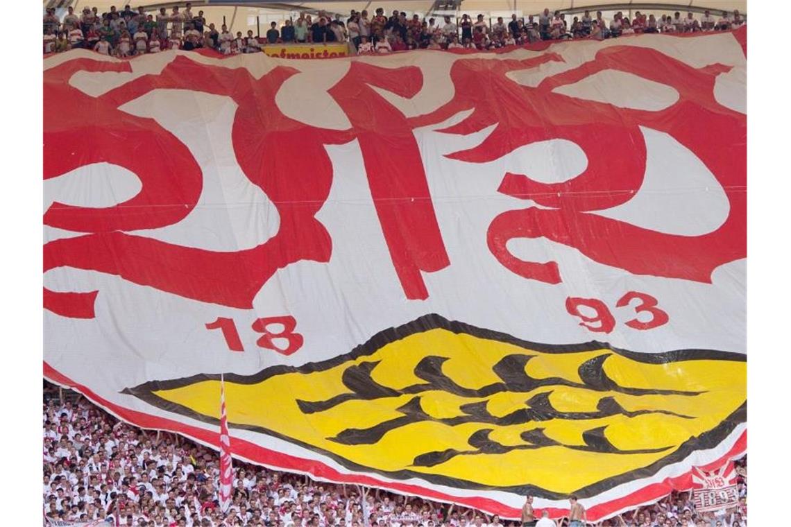 Stuttgarter Fans mit einem Banner mit dem Logo des VfB. Foto: Sebastian Kahnert/Archivbild