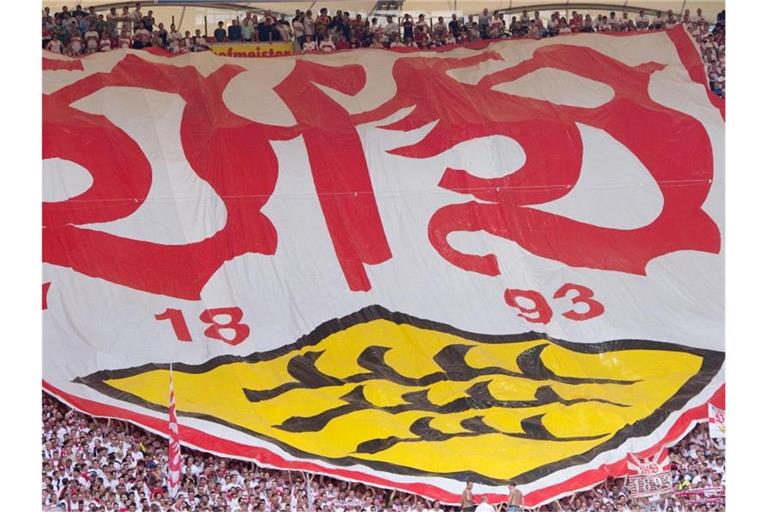 Stuttgarter Fans mit einem Banner mit dem VfB-Logo. Foto: Sebastian Kahnert/dpa/Archivbild
