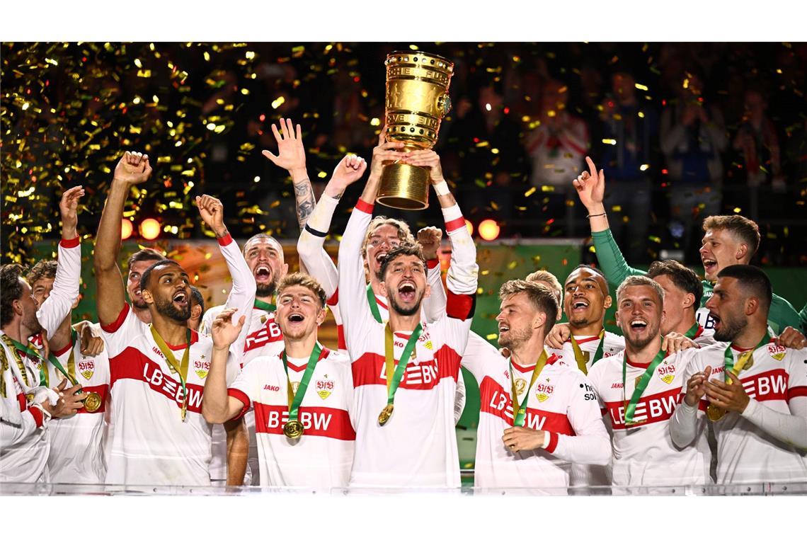 Bilder des Tages Stuttgarts Atakan Karazor hält die Trophäe in die Höhe und jubelt mit seinen Mitspielern über den Pokalsieg.