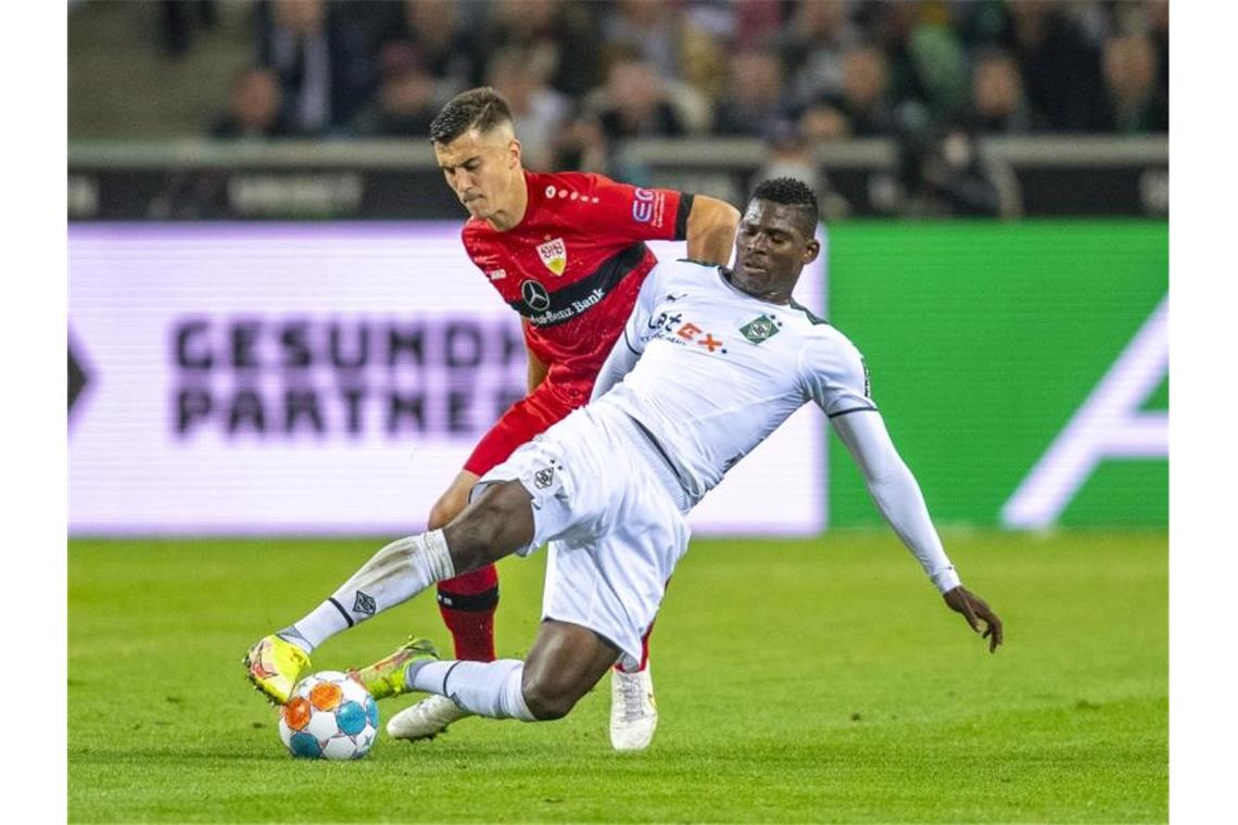 Stuttgart erkämpft sich nach Corona-Chaos 1:1 in Gladbach Stuttgarts Atakan Karazor (l) und Gladbachs Breel Embolo kämpfen um den Ball. Foto: David Inderlied/dpa