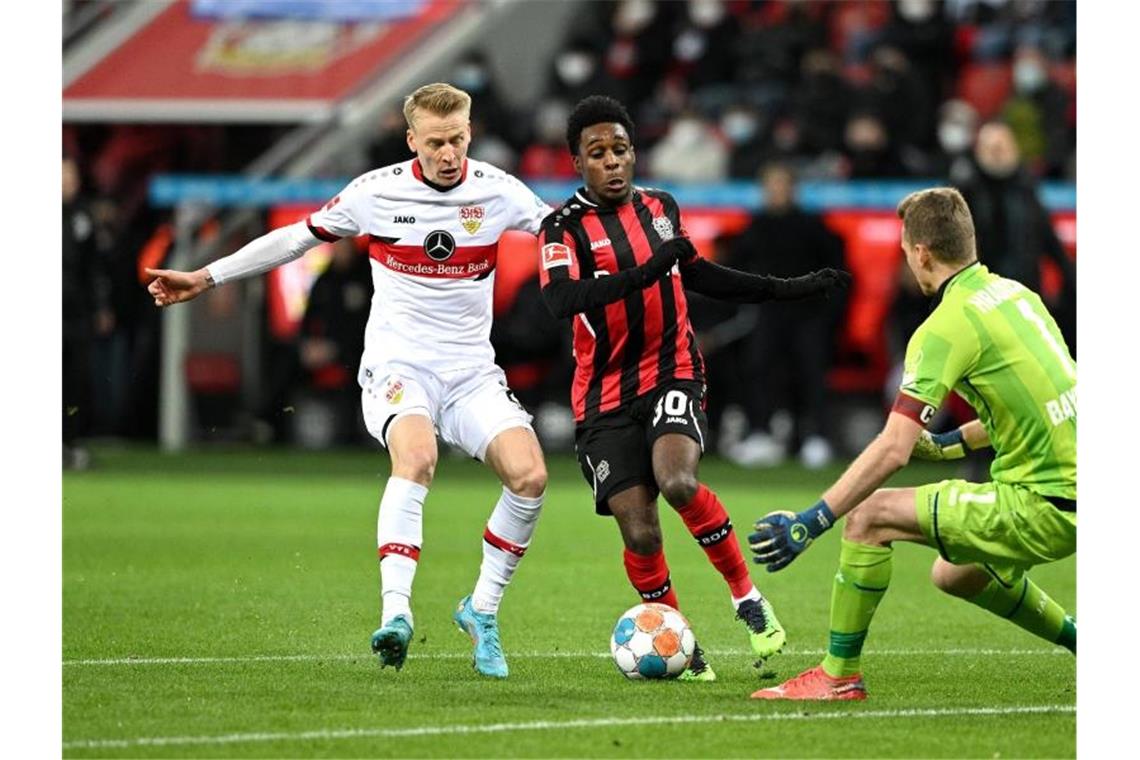 Stuttgarts Chris Führich (l-r), Leverkusens Frimpong und Leverkusens Hradecky kämpfen um den Ball. Foto: David Inderlied/dpa