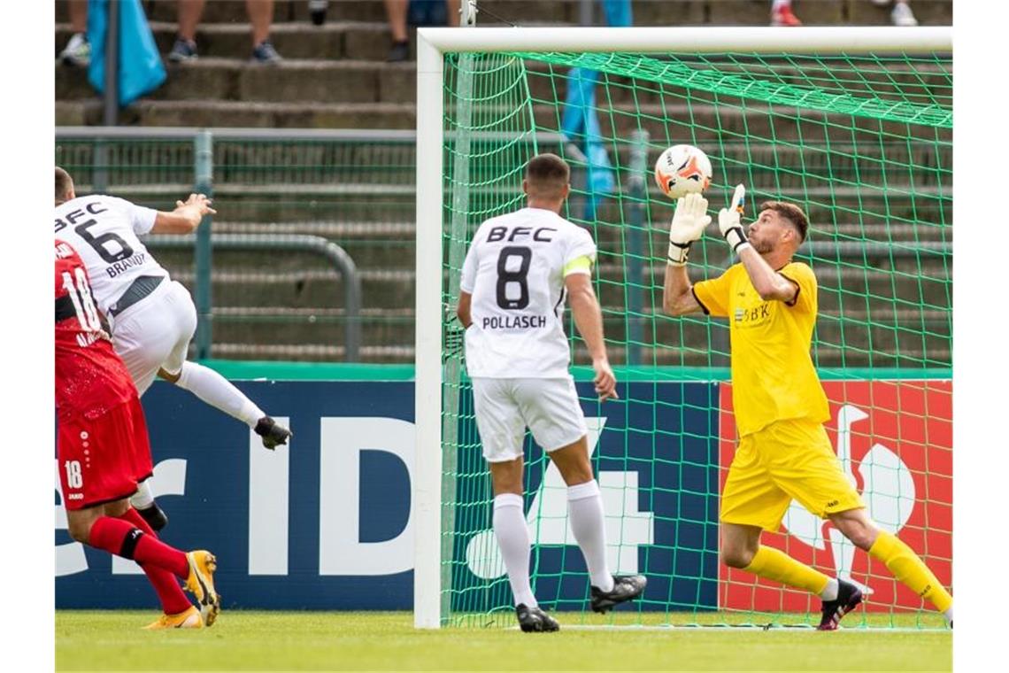 6:0 beim BFC Dynamo: Stuttgarter Rumpfteam souverän weiter Stuttgarts Hamadi Al Ghaddioui (l) trifft zum 0:1 gegen Torwart Dmitri Stajila (r) von BFC Dynamo. Foto: Andreas Gora/dpa