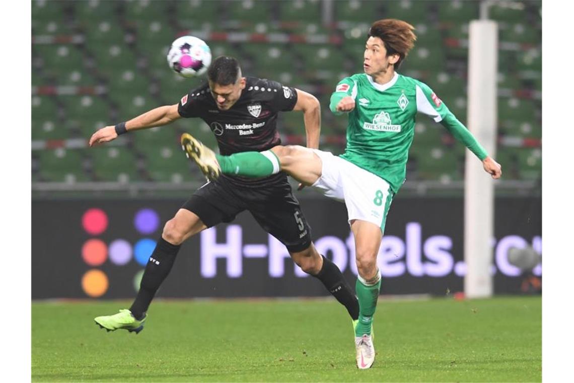 Stuttgarts Konstantinos Mavropanos (l) und Werders Yuya Osako kämpfen um den Ball. Foto: Carmen Jaspersen/dpa