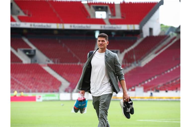 Stuttgarts Mario Gomez läuft mit Schuhen in der Hand aus der Mercedes-Benz Arena. Foto: Tom Weller/dpa