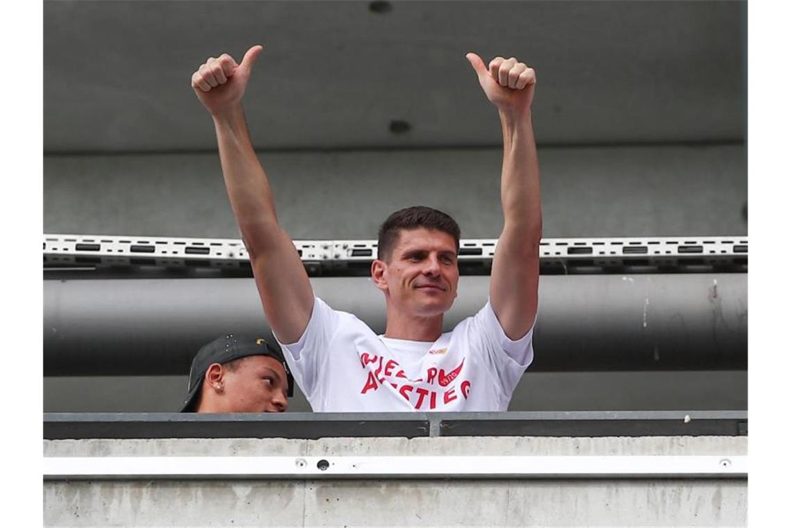 Stuttgarts Mario Gomez (r) und seine Mitspieler feiern den Aufstieg mit den Fans. Foto: Tom Weller/dpa/Symbolbild