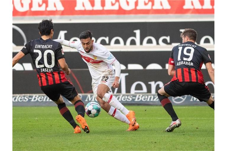 Stuttgarts Nicolas Gonzalez (M) spielt gegen Frankfurts Makoto Hasebe (l) und David Abraham. Foto: Sebastian Gollnow/dpa
