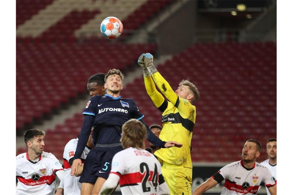 Stuttgarts Torwart Florian Müller und Herthas Niklas Stark (l) kämpfen um den Ball. Foto: Tom Weller/dpa