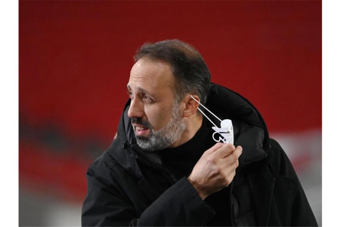 Stuttgarts Trainer Pellegrino Matarazzo nimmt seine Maske vor dem Spiel ab. Foto: Marijan Murat/dpa