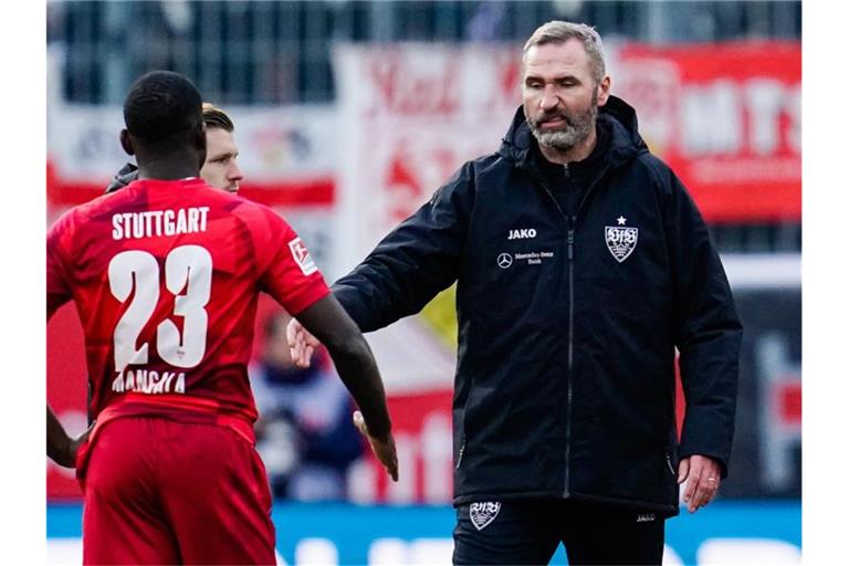 Stuttgarts Trainer Tim Walter (r) geht nach dem Spiel zu Orel Mangala. Foto: Uwe Anspach/dpa