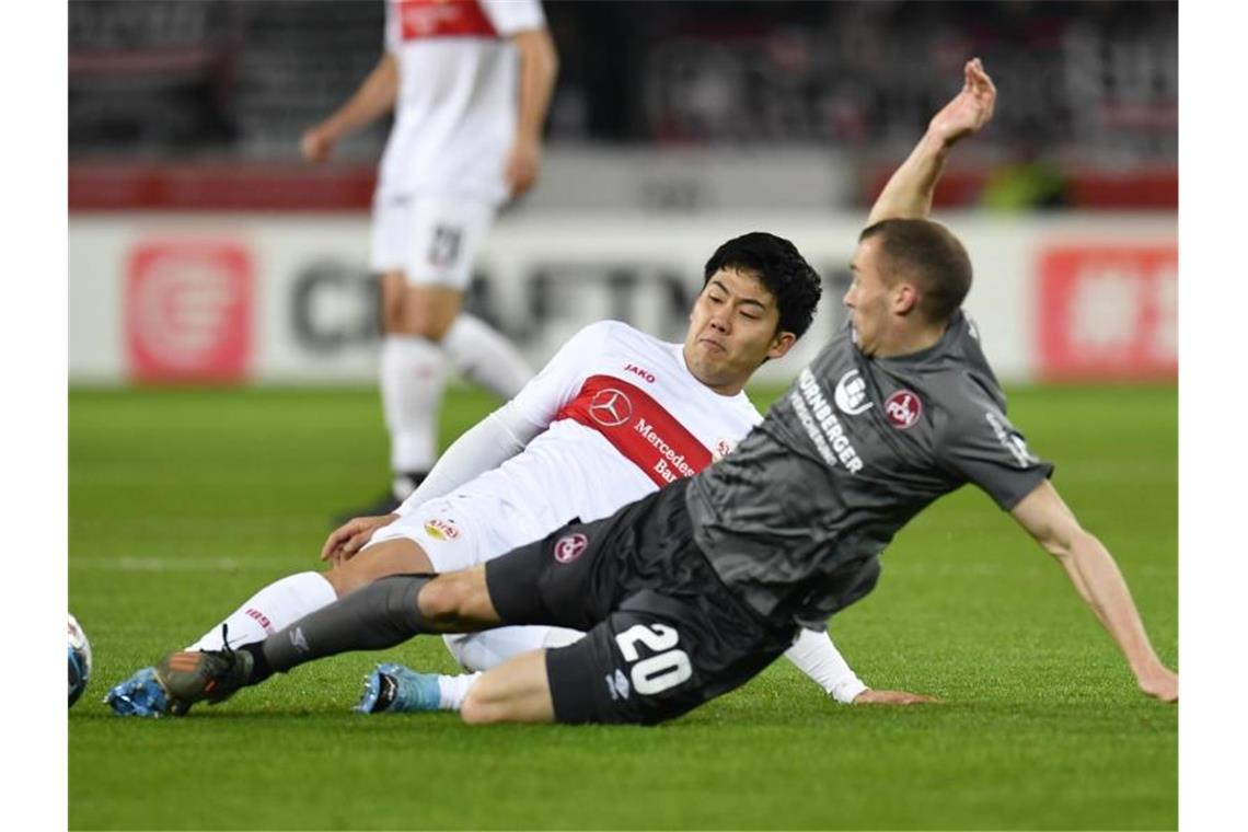 Stuttgarts Wataru Endo spielt gegen Nürnbergs Lukas Jäger (r). Foto: Thomas Kienzle/dpa