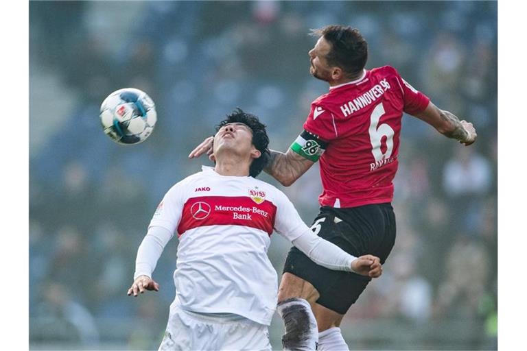 Stuttgarts Wataru Endo und Hannovers Marvin Bakalorz (l-r.) im Zweikampf um den Ball. Foto: Swen Pförtner/dpa