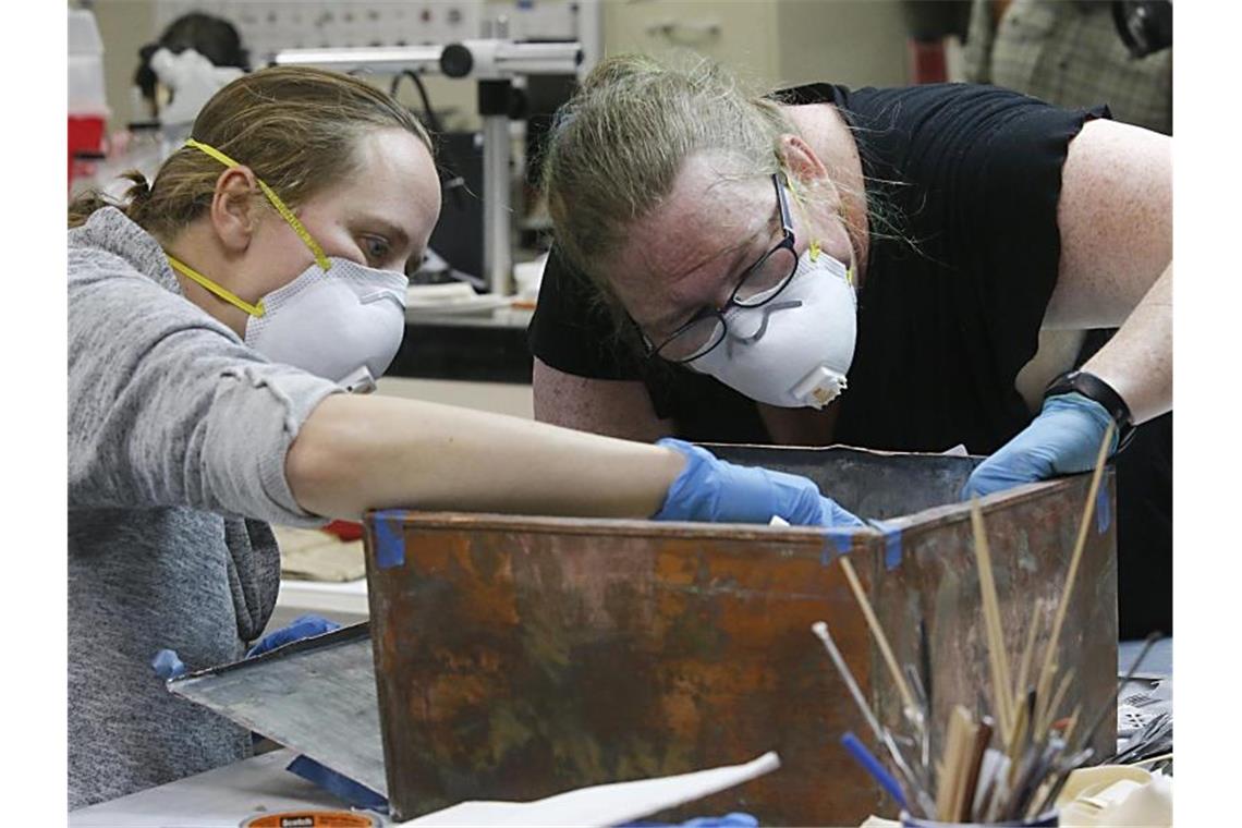 Zweite Zeitkapsel aus dem Jahr 1887 in Virginia geöffnet Sue Donovan (l) und Kate Ridgeway untersuchen die Artefakte der Zeitkapsel. Foto: Bob Brown/Richmond Times-Dispatch/AP/dpa