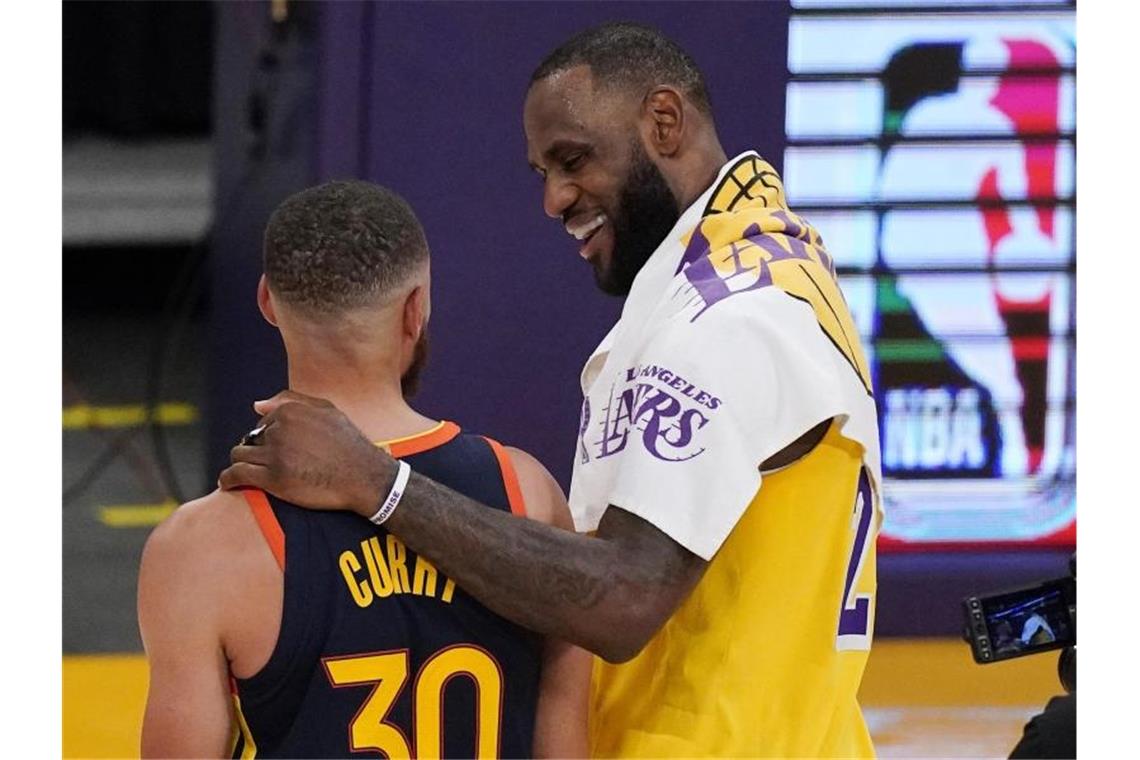 LeBron James wirft die Lakers in die NBA-Playoffs Superstars unter sich: LeBron James (r) und Stephen Curry nach dem Lakers-Sieg gegen die Golden State Warriors. Foto: Mark J. Terrill/AP/dpa