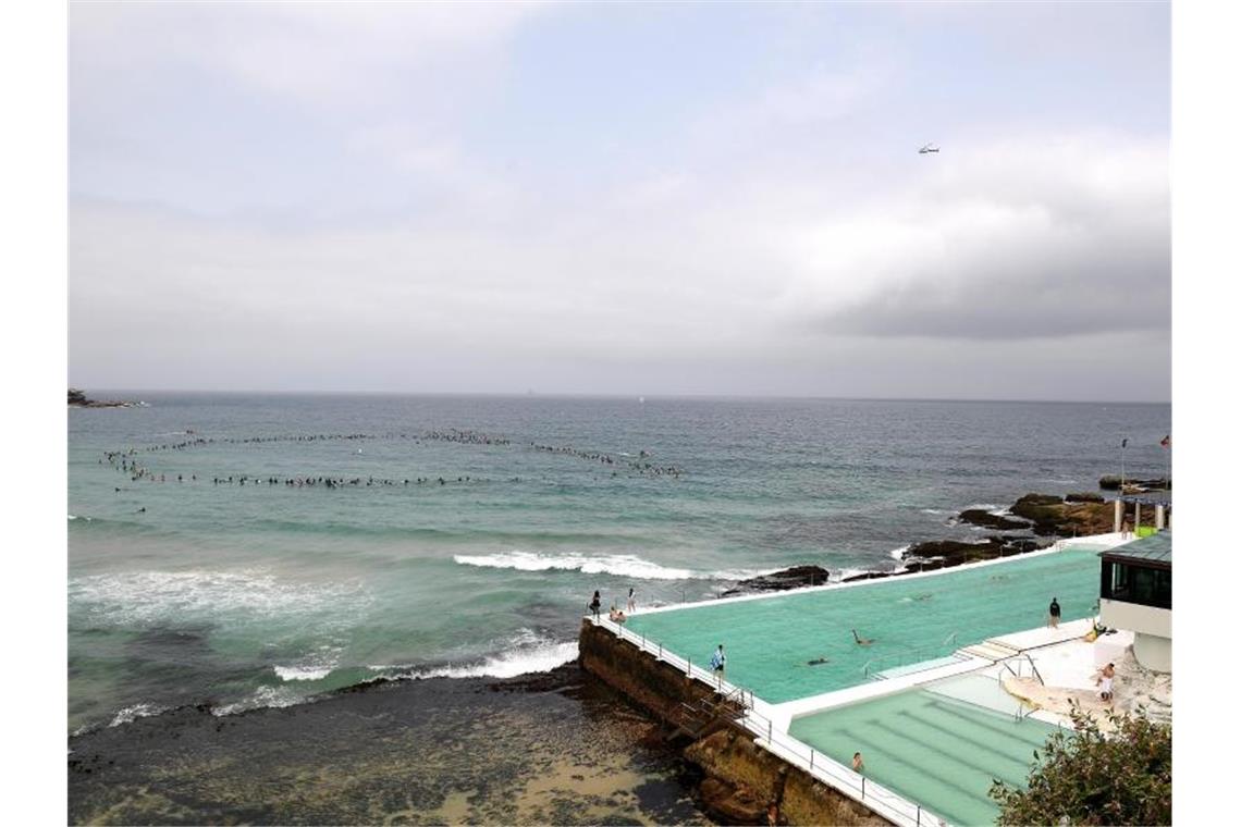 Surfer nehmen an einer Umweltaktion am Bondi Beach teil. In ganz Australien wurde gegen die Pläne des norwegischen Ölkonzerns Equinor protestiert, in den Gewässern vor der Großen Australischen Bucht nach Öl zu bohren. Foto: Dan Himbrechts/AAP/dpa