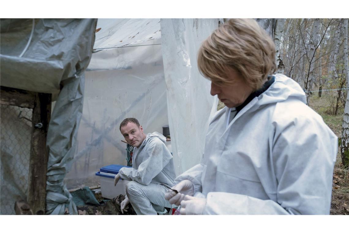 Susanne Bonard (Corinna Harfouch, re.) und Robert Karow (Mark Waschke, li.) werten die Spuren am Tatort aus, wo der tote Obdachlose im Wald entdeckt wurde.