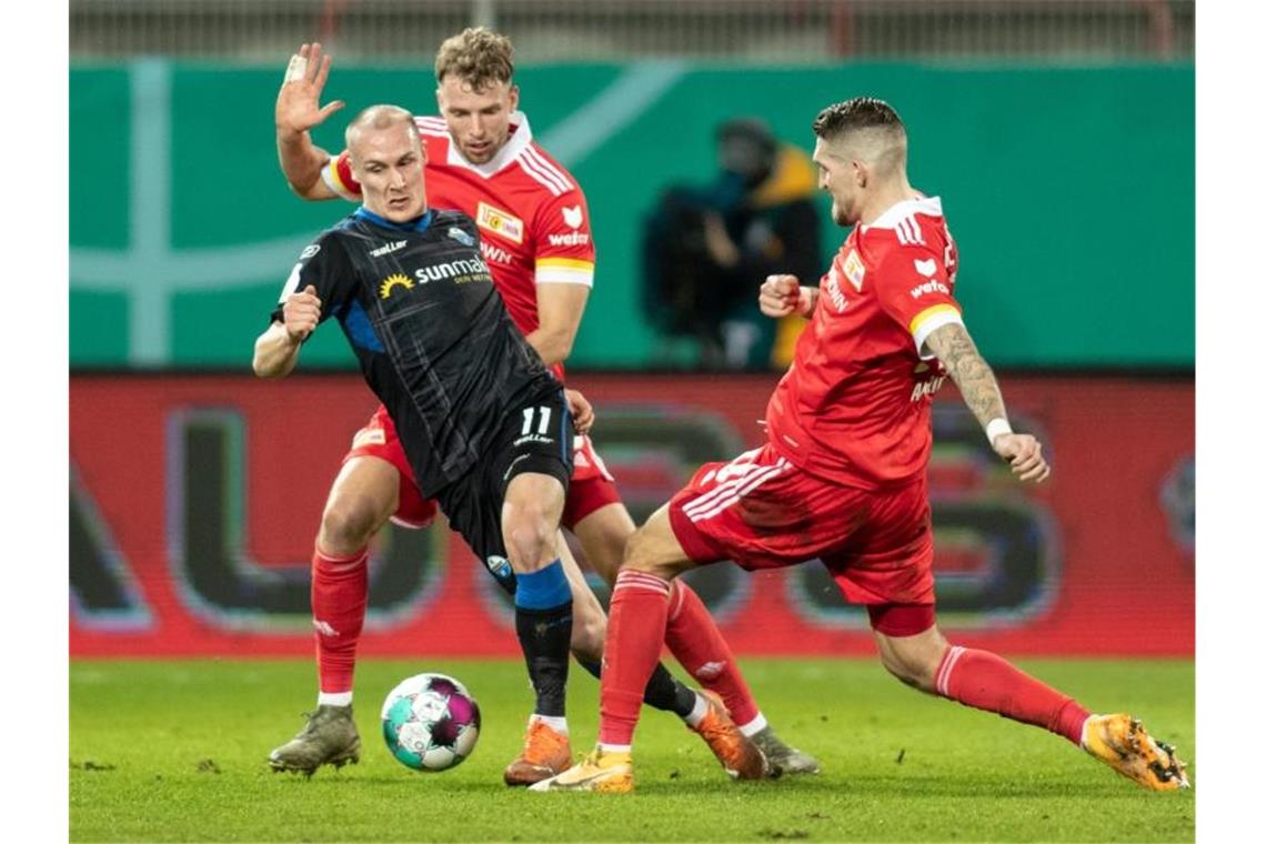 Sven Michel (l-r) vom SC Paderborn kämpft gegen Berlins Marvin Friedrich und Robert Andrich um den Ball. Foto: Andreas Gora/dpa