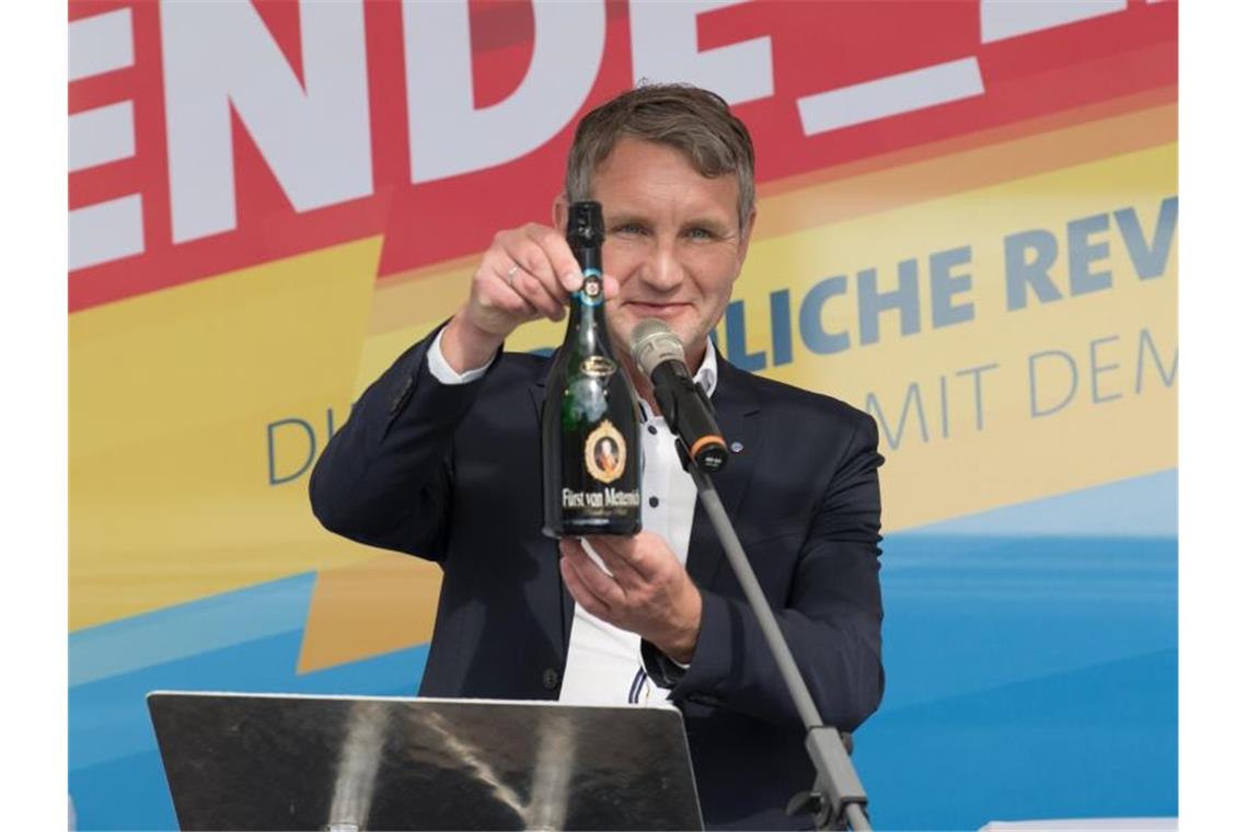 Symbolisches Geschenk für vermeintliche Verfassungsschützer im Publikum: Björn Höcke mit einer Flasche Sekt. Foto: Jörg Carstensen