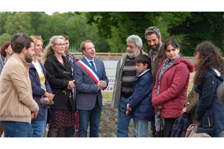 Szene mit July Delpy als Lehrerin Joëlle(3. v. li.): Die Einwohner von Paimpont heißen Familie Fayad willkommen.