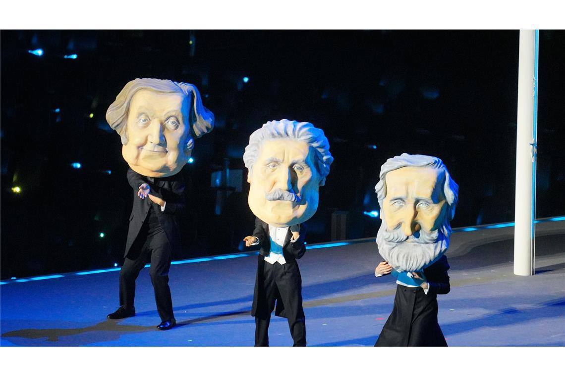 Tänzer tragen Masken der italienischen Komponisten Giuseppe Verdi, Giacomo Puccini and Gioachino Rossini während der Eröffnungsfeier unter dem Motto „Armonia“.