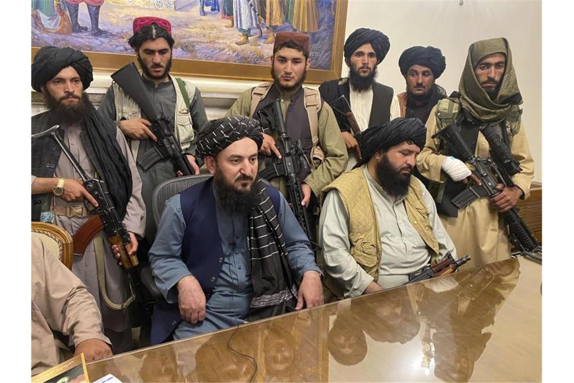 Taliban-Kämpfer sitzen in einem Raum des Präsidentenpalastes in Kabul. Foto: AP/dpa