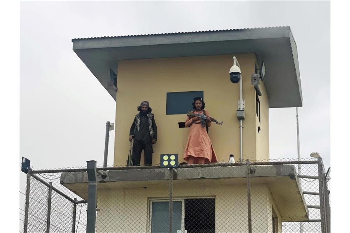 Evakuierung aus Kabul läuft - Luftbrücke geplant Taliban-Kämpfer stehen auf einem Turm des Innenministeriums Wache. Foto: -/AP/dpa