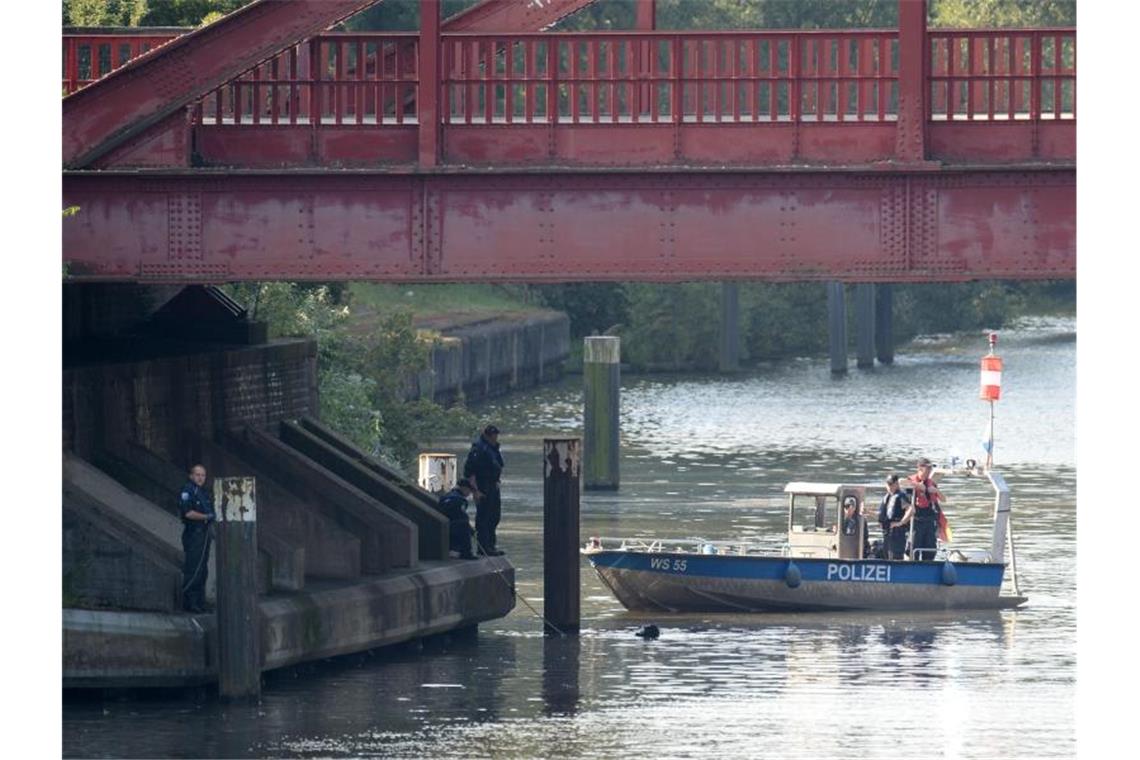 Taucher der Polizei suchen im Tiefstackkanal nach Leichenteilen einer getöteten Prostituierten in Hamburg. Foto: Daniel Reinhardt/dpa