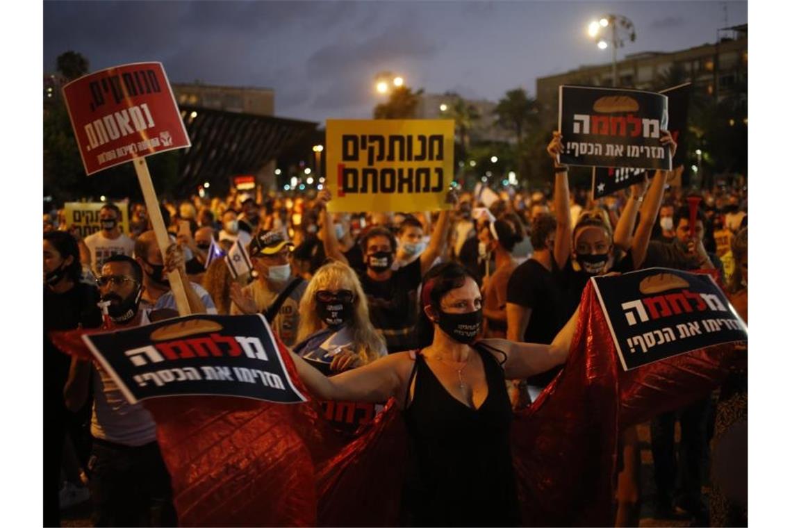 Tausende Israelis versammelten sich auf dem Rabin-Platz in Tel Aviv, um gegen Premierminister Netanjahu und die wirtschaftliche Notlage infolge von Einschränkungen wegen der Corona-Pandemie zu demonstrieren. Foto: Ariel Schalit/AP/dpa