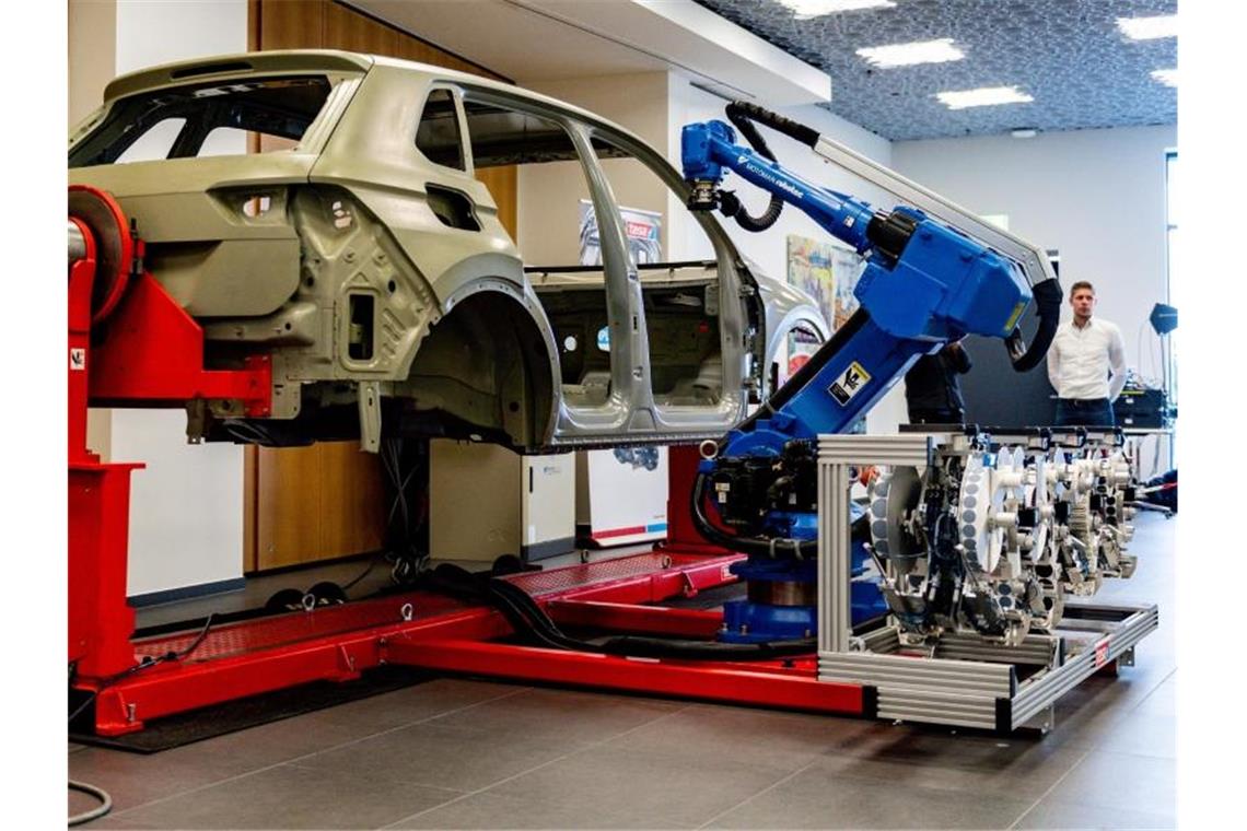 Vom Reifenflicken zum Handy: 125 Jahre technisches Klebeband Techniker der Tesa SE demonstrieren die Funktionsweise eines Industrieroboters, der mit Klebepads Löcher in einer Autokarosserie schließt. Foto: Axel Heimken/dpa