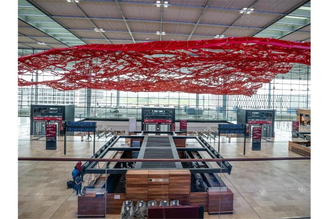 Techniker und Arbeiter sind in der Abflughalle des neuen Flughafens Berlin-Brandenburg Willy-Brandt unterwegs. Foto: Michael Kappeler/dpa