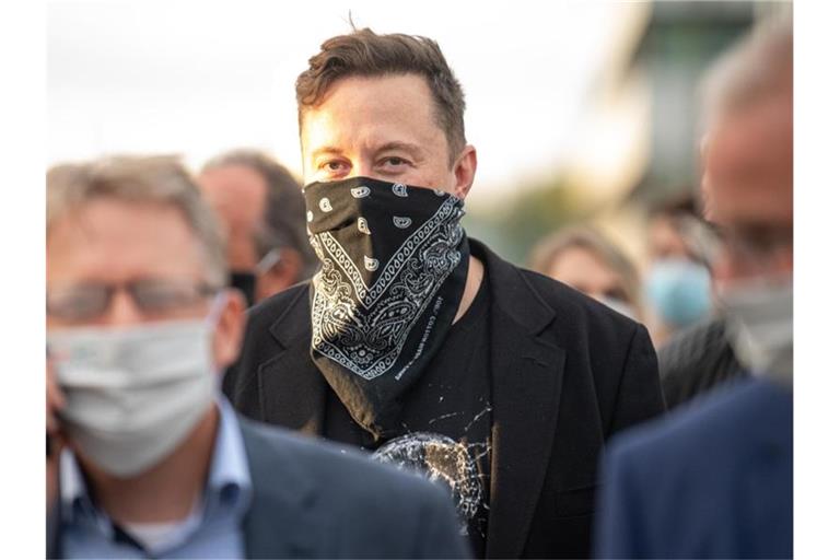 Technologieunternehmer Elon Musk geht während seines Besuchs des Biotech-Unternehmens Curevac von einem Gebäude ins nächste. Foto: Sebastian Gollnow/dpa