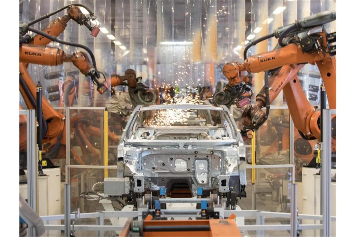 Teile eines VW Passat werden im Karosseriewerk im Volkswagen Werk Emden von Roboter zusammengefügt. Foto: Jörg Sarbach/dpa