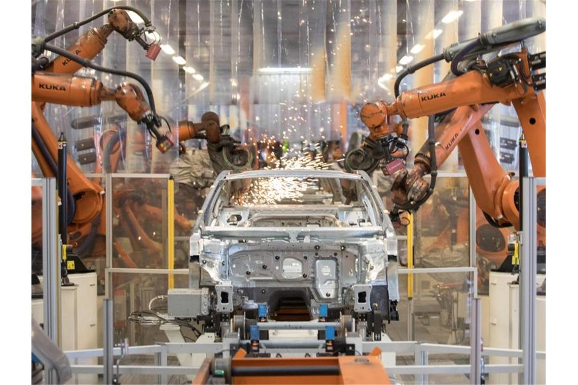 Teile eines VW Passat werden im Karosseriewerk von VW von Robotern zusammengefügt. Foto: Jörg Sarbach/dpa