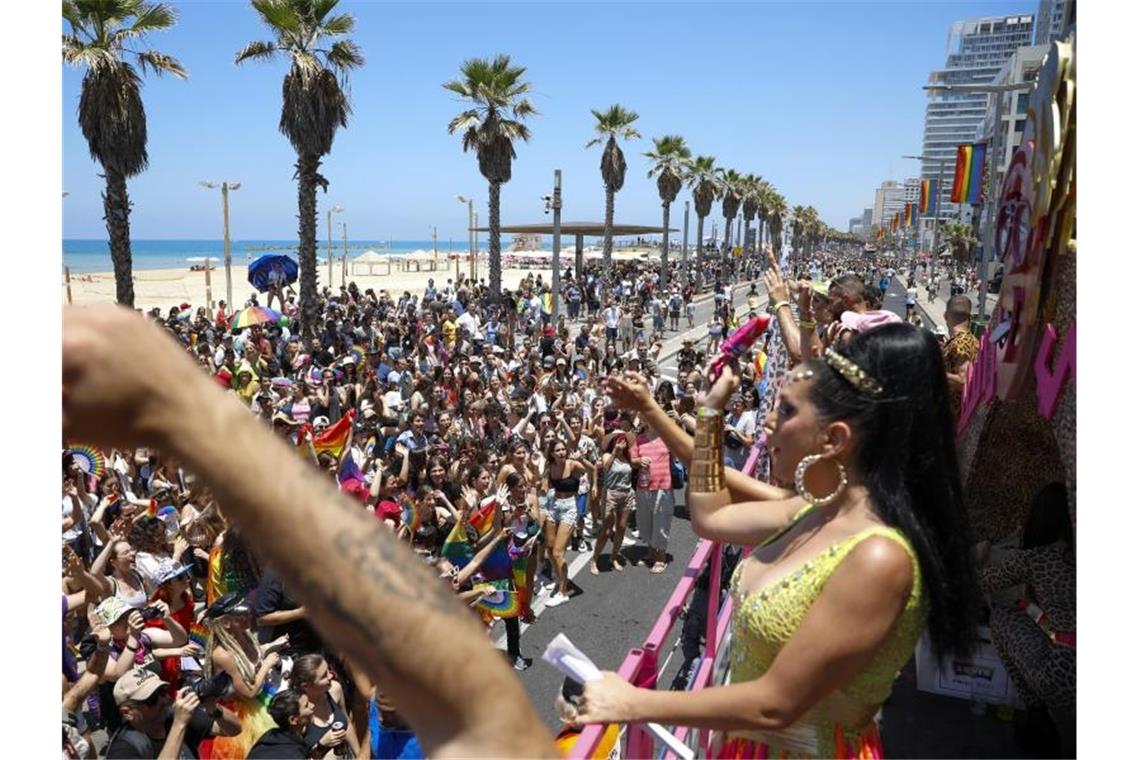 Tel Aviv: Über 100.000 Menschen feiern bei Gay-Pride-Parade Teilnehmende winken von einem fahrenden Wagen aus den Zuschauerinnen und Zuschauern zu. Foto: Ariel Schalit/AP/dpa